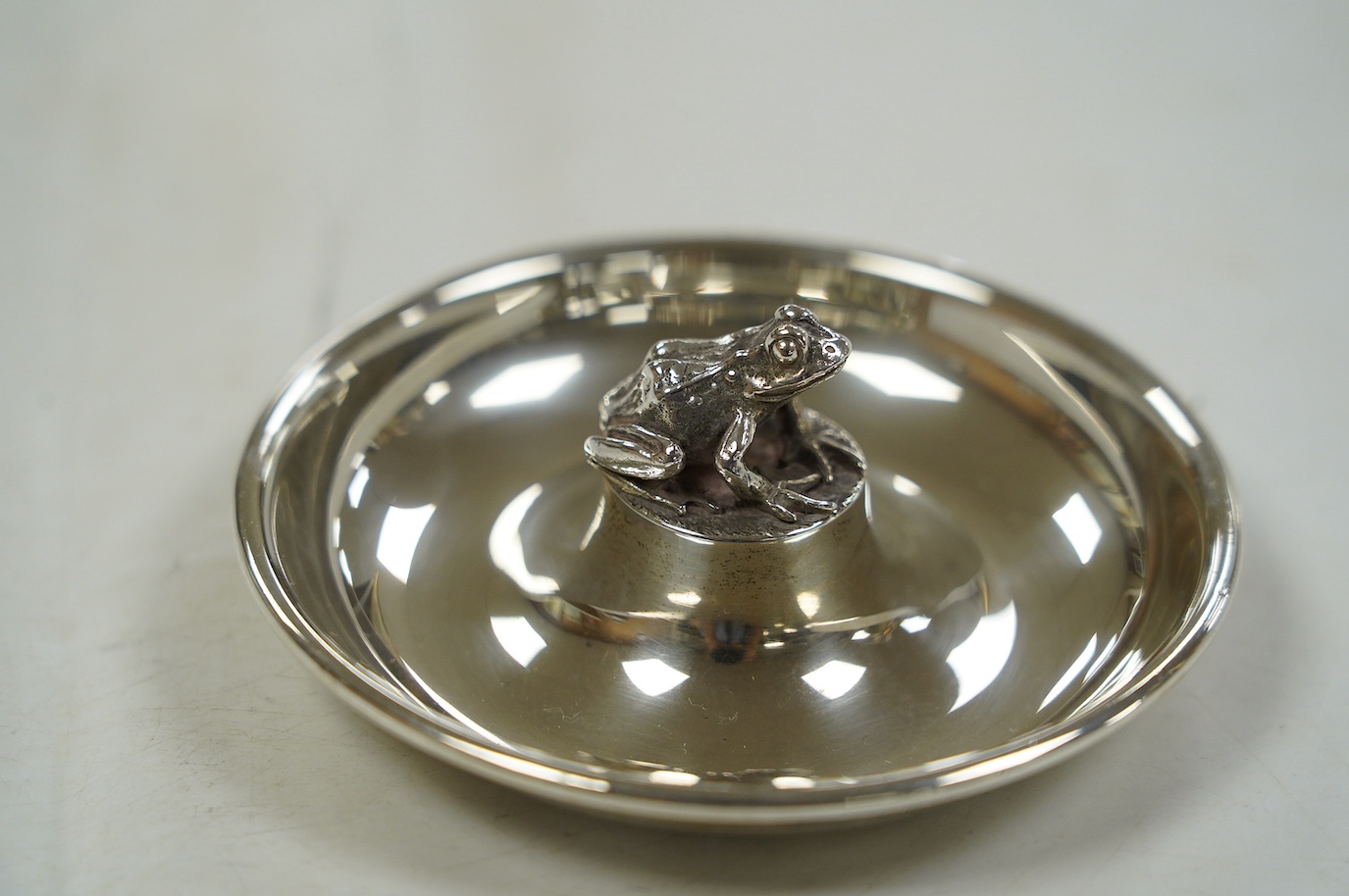 An Elizabeth II silver circular dish with central model of a frog, by Brian Leslie Fuller, London, 1996, 91mm. Condition - fair to good